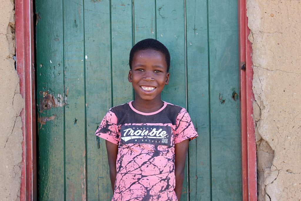 A South African girl outside her home